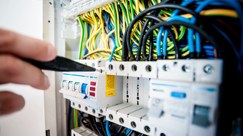 hand working on the home electrical panel