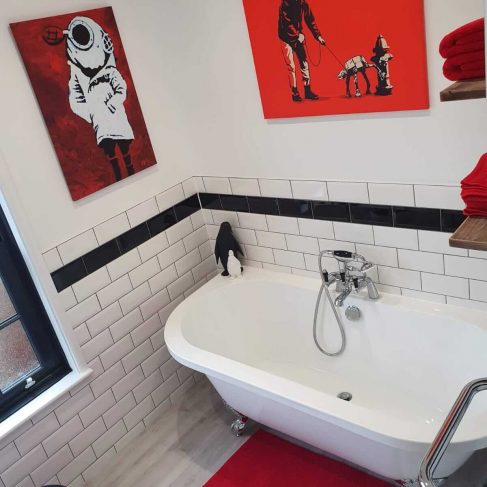 Black, white and red bathroom, with rolltop bath