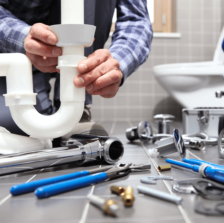 Professional plumber installing bathroom pipes.