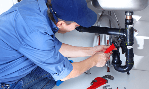 Picture of a male professional plumber fixing a sink pipe